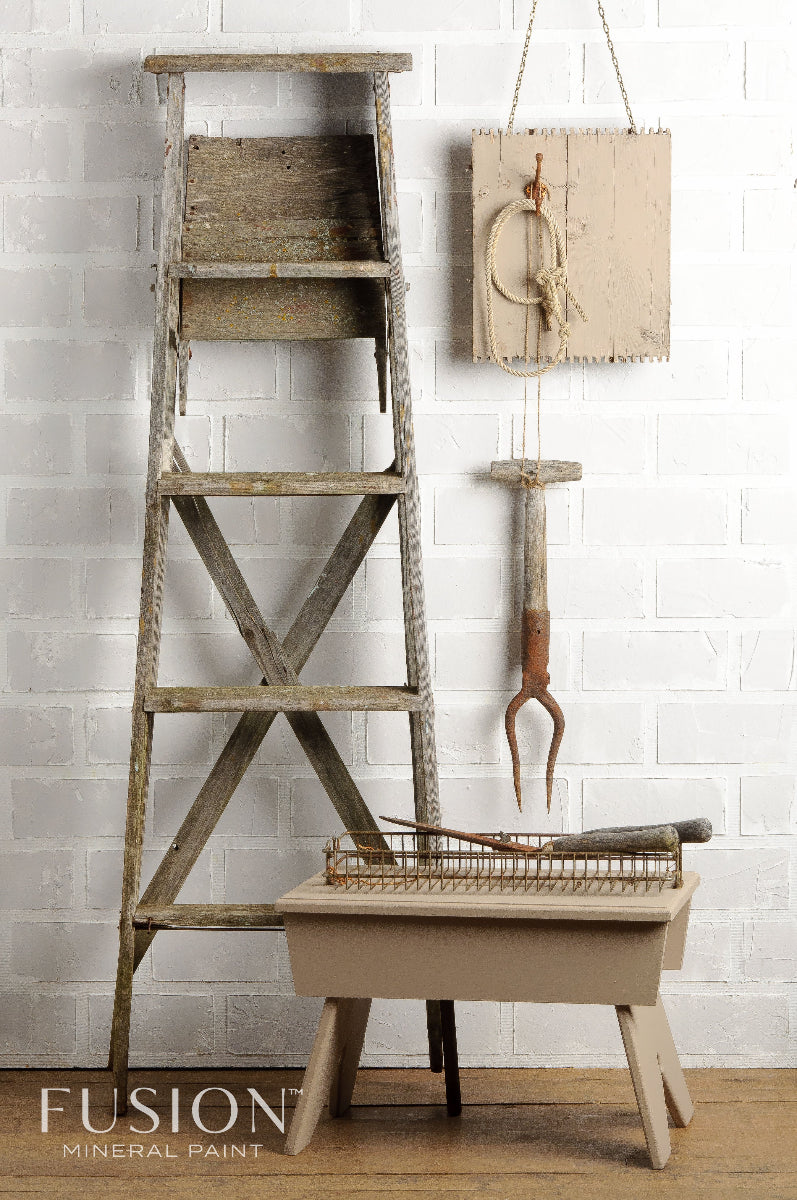 Wooden ladder and table painted in Algonquin from the Fusion Mineral Paint range against a white brick wall