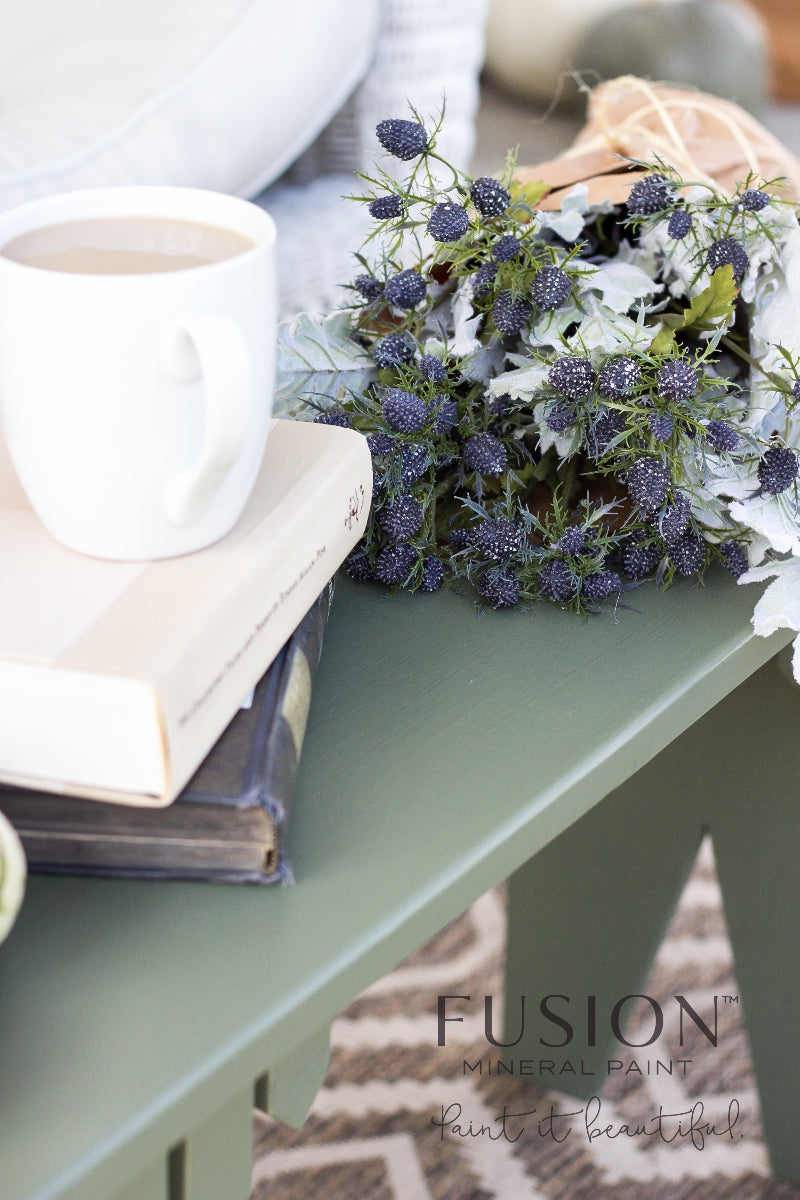 Table painted in Bayberry Fusion Mineral Paint with a white mug, book, and floral arrangement