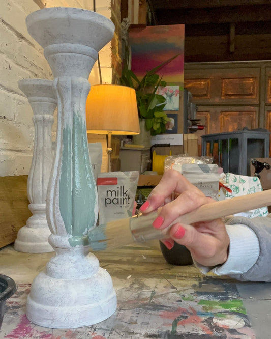 Jodi from Upcycled and Reloved by Jodi applying paint to a candlestick in her workshop