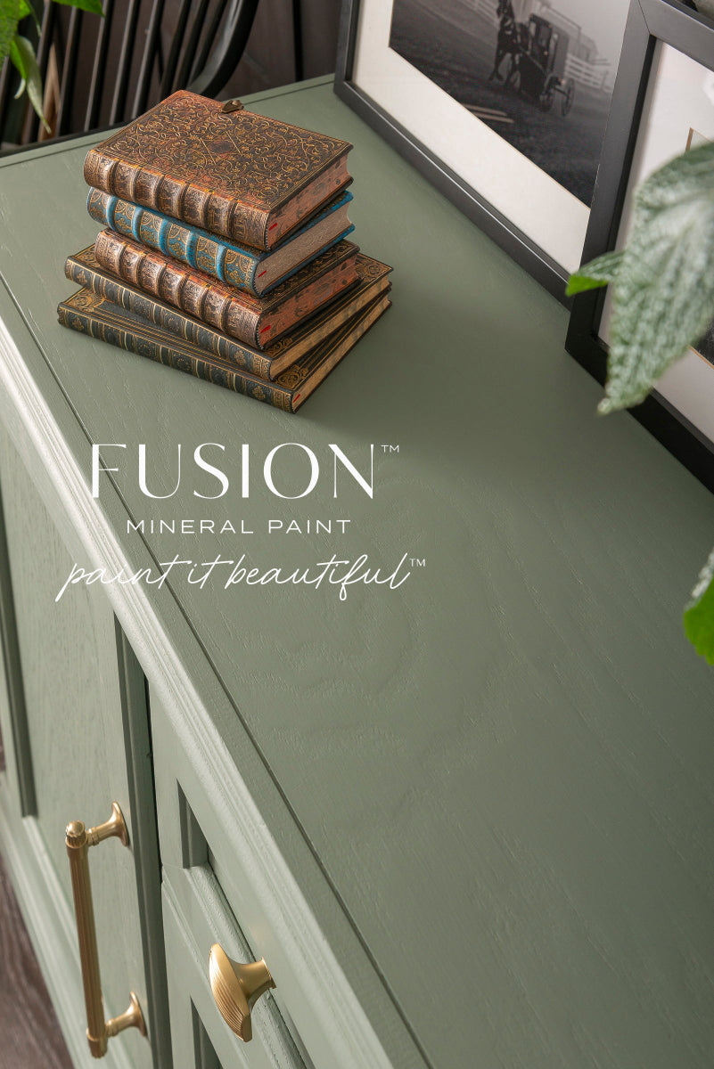 Cabinet painted in Carriage House from Fusion Mineral Paint, a green-grey shade, with decorative books.