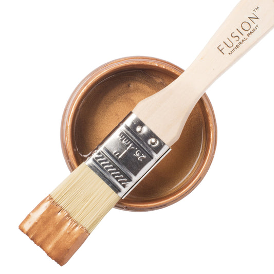 Fusion Mineral Paint brush with a tin of Copper-coloured Metallic paint on a white background