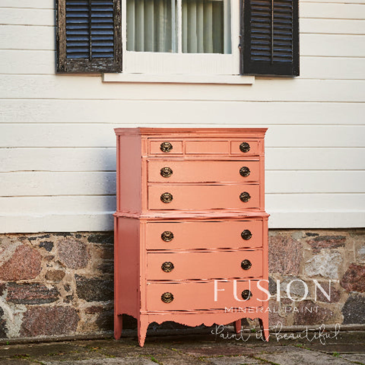 Dresser painted in Coral Fusion Mineral Paint placed against a white wall with black shutters