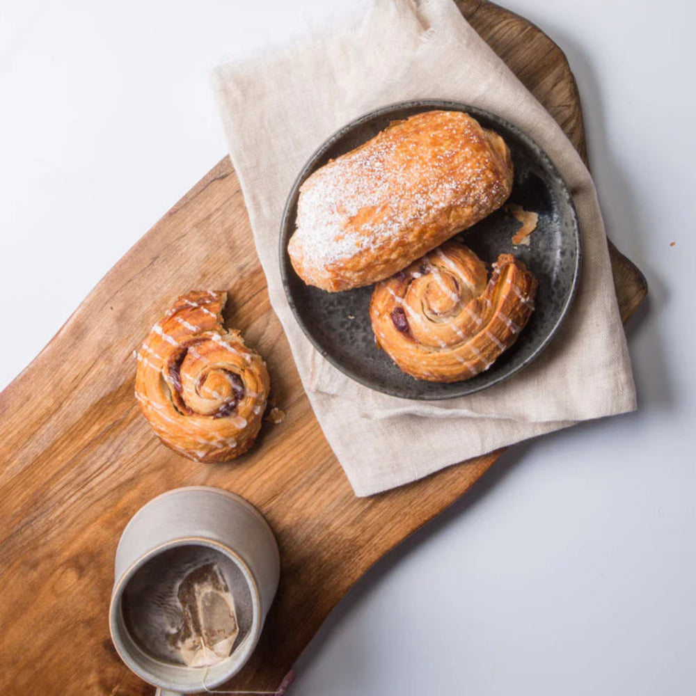Pastries on a wooden board oiled with Fusion Hemp Oil with a teacup on a light background