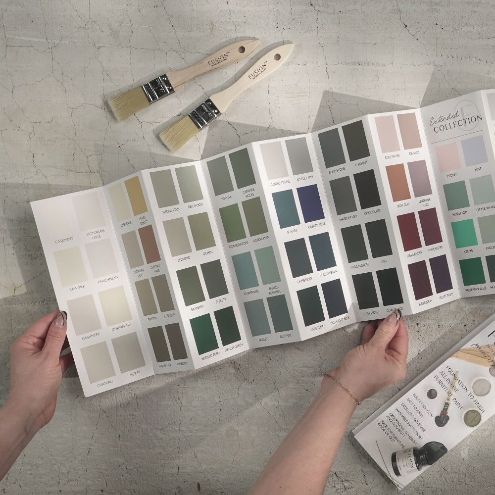 Person holding an accordion colour card of Fusion Mineral Paint