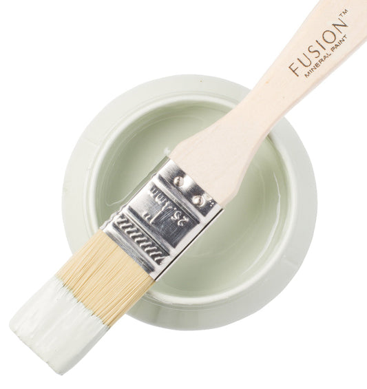 Paint brush with Inglenook paint from the Fusion Mineral Paint range laid across a container on a white background
