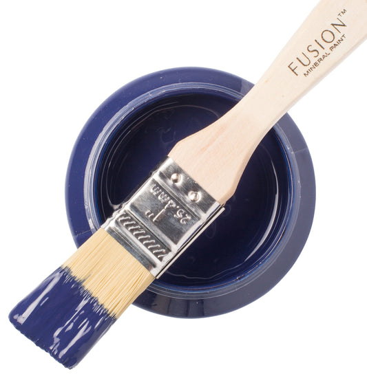 Paint brush with Liberty Blue paint from the Fusion Mineral Paint range sat atop a container on a white background