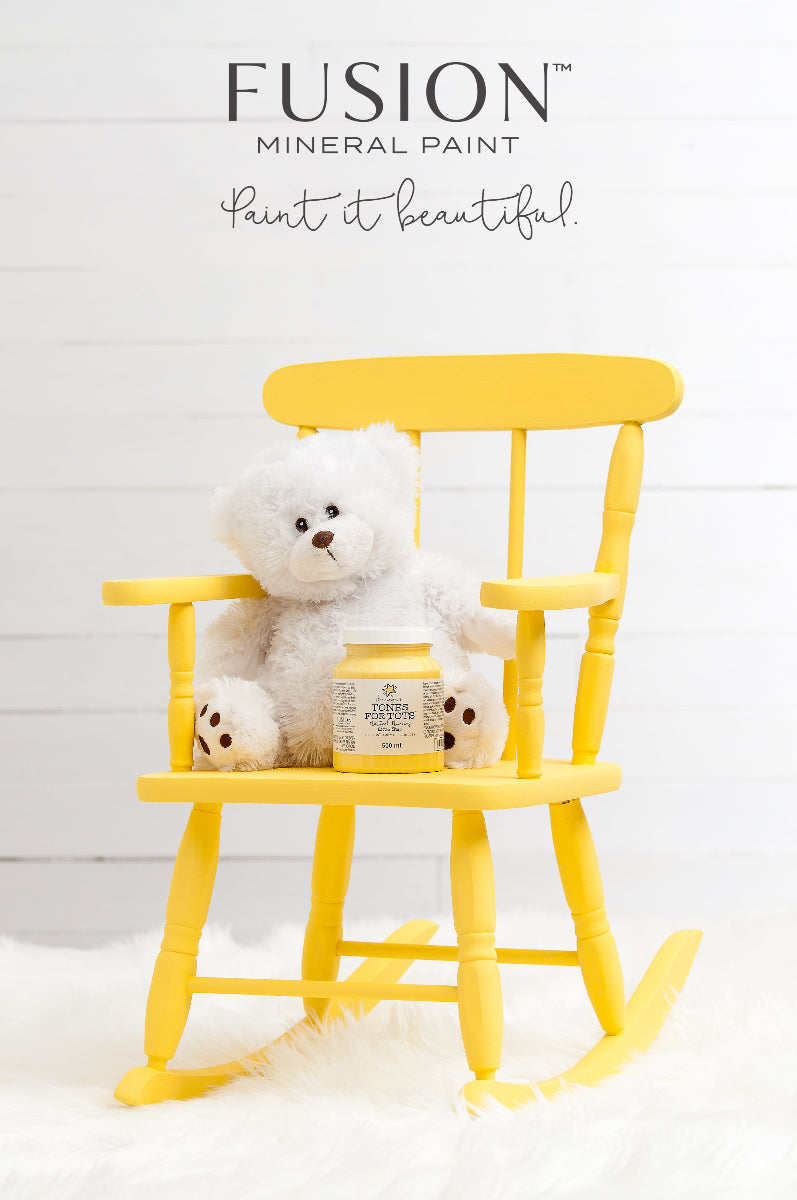 Yellow rocking chair painted in Little Star from the Fusion Mineral Paint range with plush toy on a white background