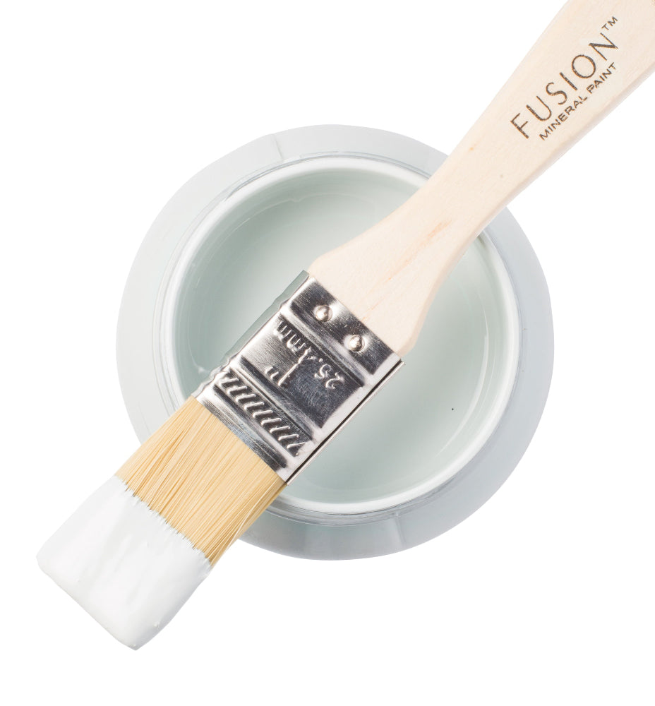 Paint brush with Little Whale paint from the Fusion Mineral Paint range sat atop a container on a white background