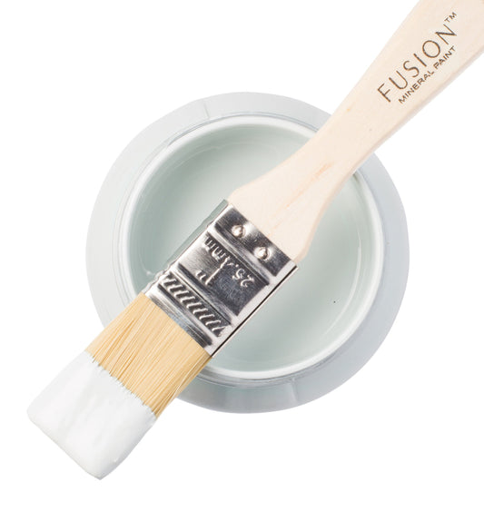 Paint brush with Little Whale paint from the Fusion Mineral Paint range sat atop a container on a white background