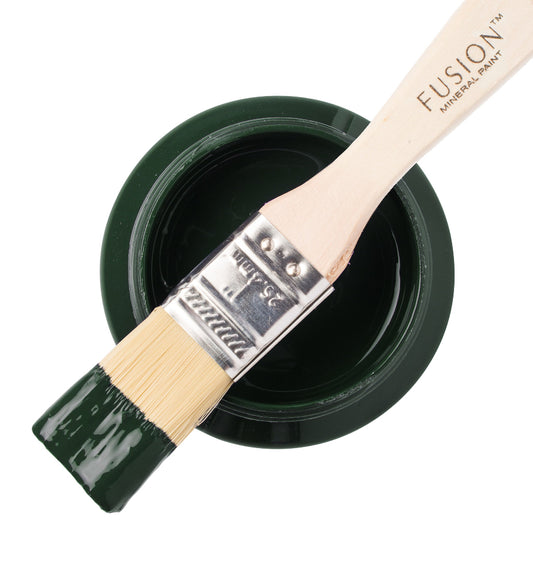 Paint brush with Manor Green paint from the Fusion Mineral Paint range sat atop a container on a white background