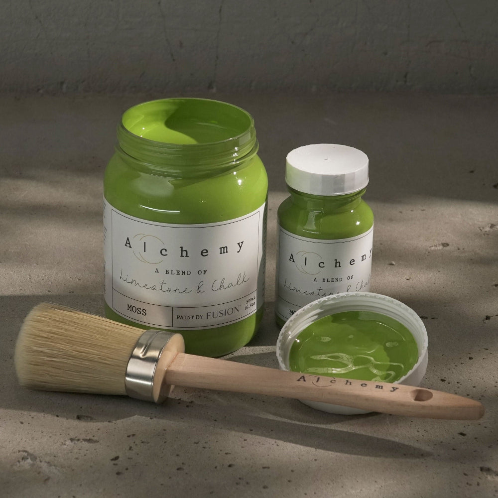 Jars of bright green Moss paint from Alchemy by Fusion with a brush on a textured surface