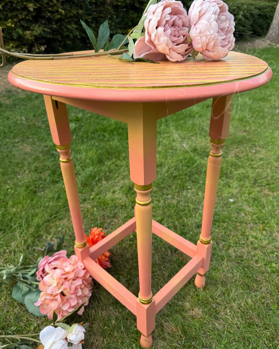 a bright side table colourful painted side table with four legs showing pink and yellow blended paint work and hand painted jagged stripes on top
