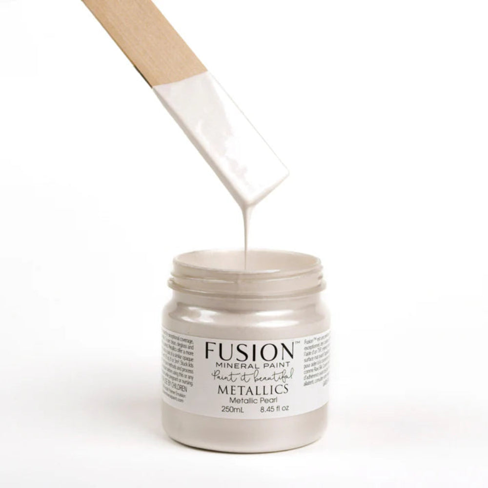 Jar of Fusion Mineral Paint Metallic Pearl with a brush dripping paint on a white background