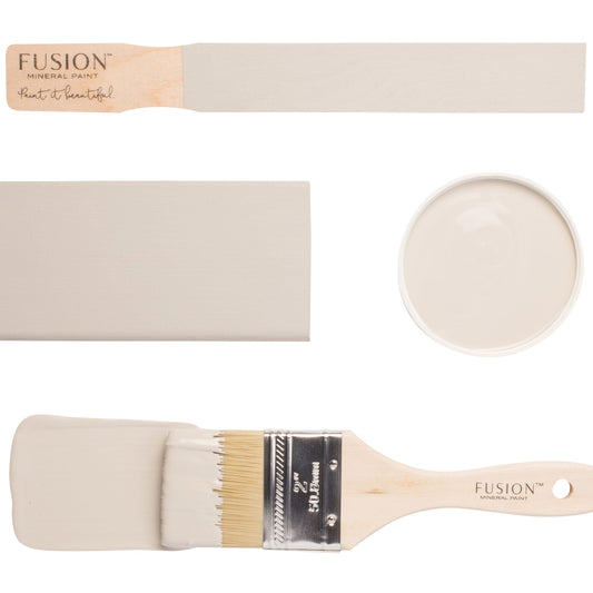Fusion paintbrushes with Putty furniture paint sample on a brush and a sample stick. Creamy beige furniture paint sample on a white background