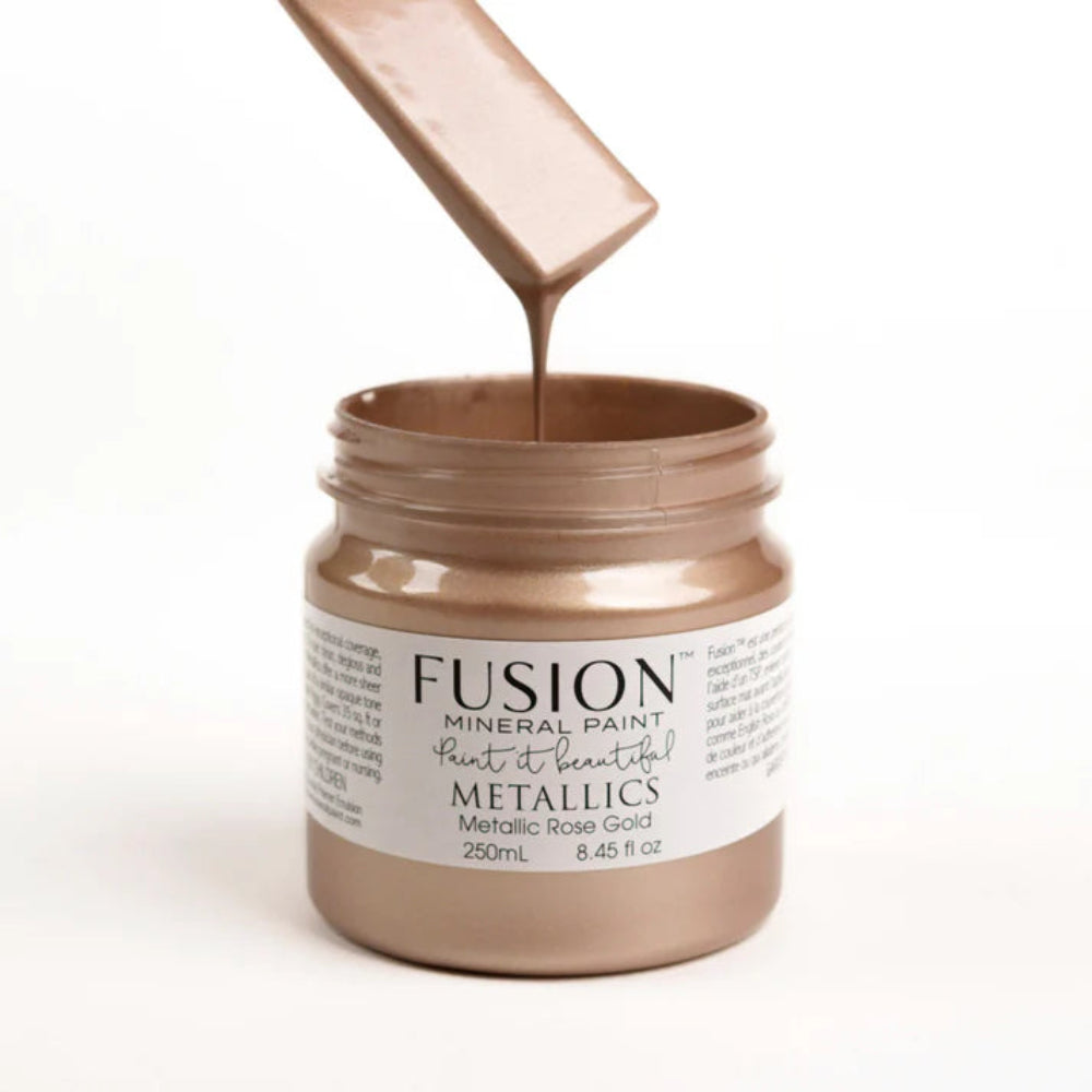 Jar of Fusion Mineral Paint with a Metallic Rose Gold colour, showing the paint being poured