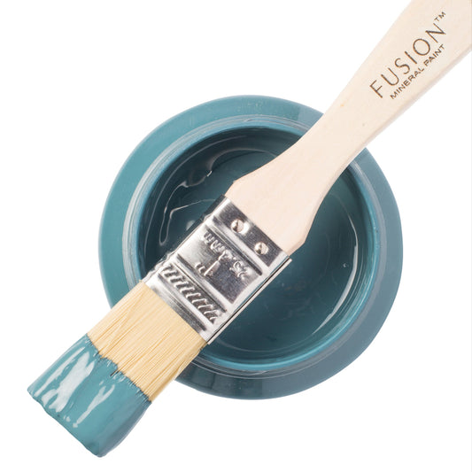 Paint brush dipped in Seaside from the Fusion Mineral Paint range resting on top of a jar of open paint