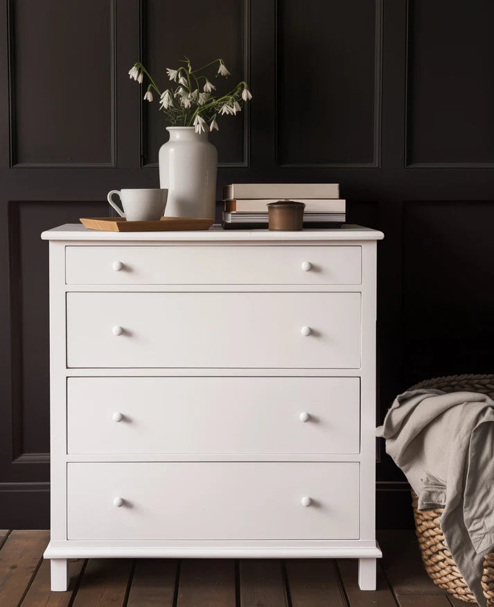 Dresser painted in Snowdrop white Fusion Mineral Paint with decorative items against a dark panelled wall
