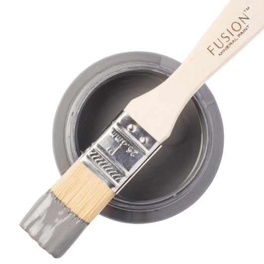 Paint brush dipped in Soap Stone from Fusion Mineral Paint resting on an open paint jar