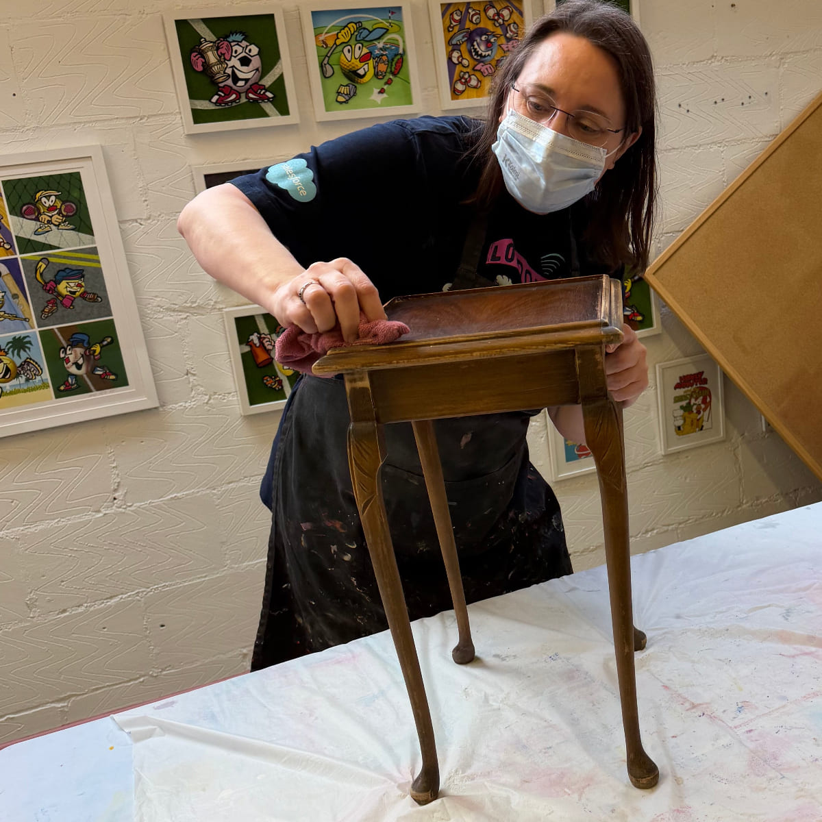 Person cleaning a sidetable at an Upcycling course in The Stockroom | Leatherhead framed.