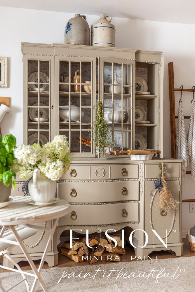 Vintage-style dining room with a large cabinet painted with Fusion Mineral Paint in Tapestry, a greeny beige.
