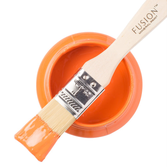 Tuscan Orange Fusion Mineral Paint on a brush resting on an open paint  jar against a white background