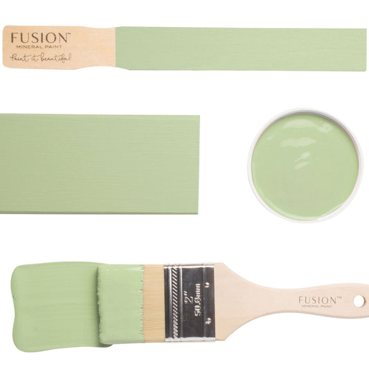 Paintbrushes with samples of Upper Canada Green paint on a white background
