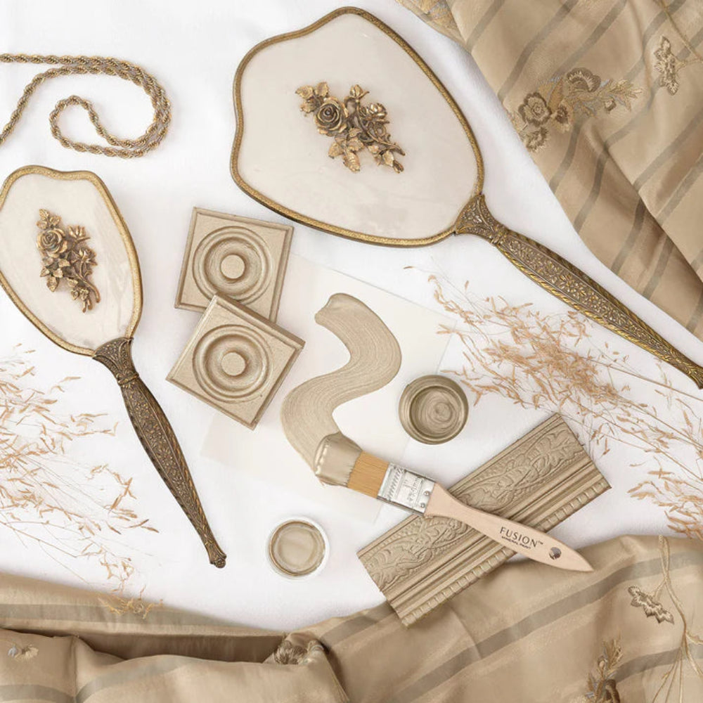 Vintage Gold Metallic items including a brush, decorative elements, and fabric on a white background