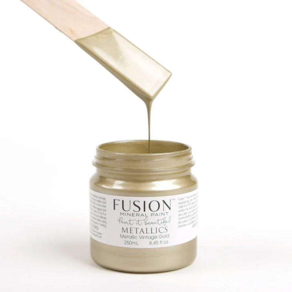 Fusion Mineral Paint jar in Vintage Gold Metallic with a wooden applicator on a white background