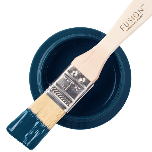 Paint brush with blue Willowbank Fusion Mineral Paint resting on a container