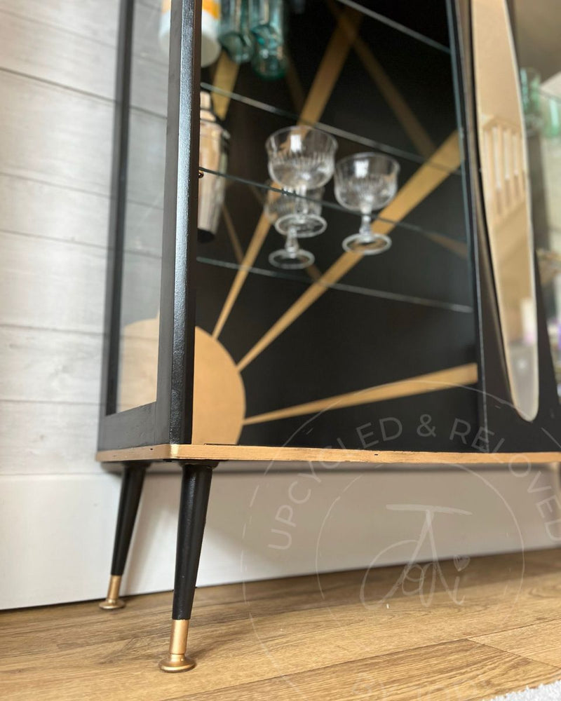 A close-up of the black and gold legs on an Art Deco drinks cabinet, with gold gilding wax detail added by Upcycled & Reloved by Jodi.
