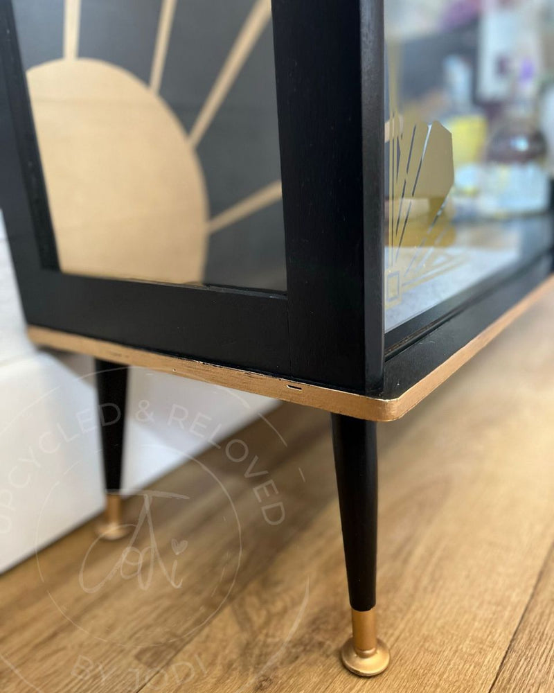 A close-up of the black and gold legs on an Art Deco drinks cabinet, with gold gilding wax detail added by Upcycled & Reloved by Jodi.