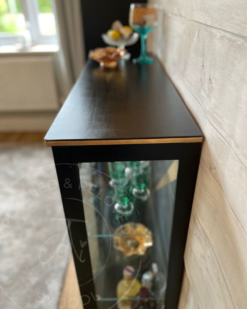 A black painted glass cabinet with gold edging detail, restyled as an Art Deco drinks cabinet from Upcycled & Reloved by Jodi. 