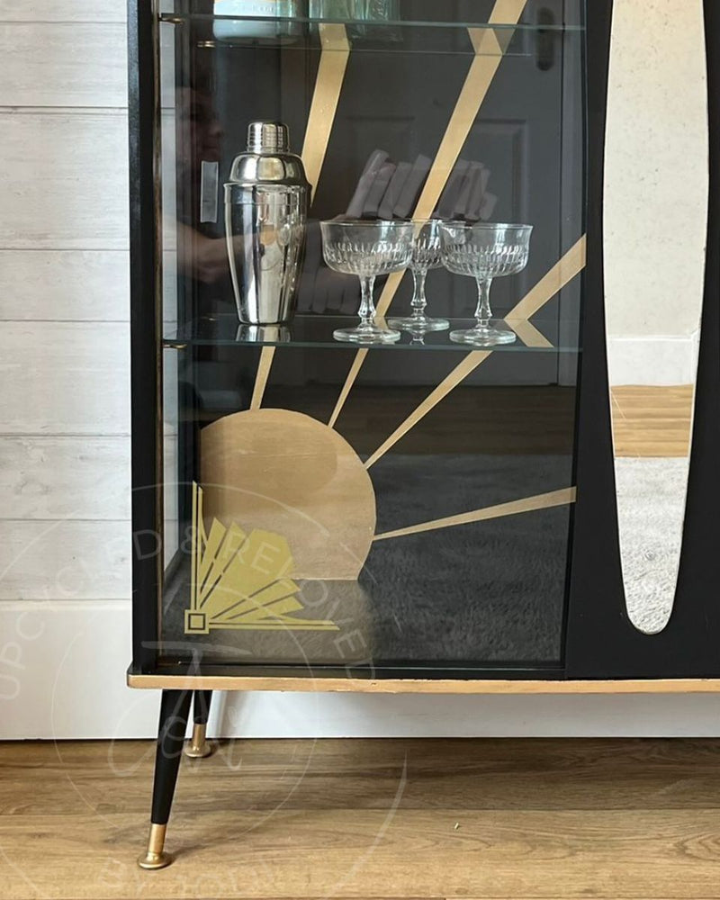 Gold Art Deco glass transfers on the doors of a black upcycled cocktail cabinet, with a painted sunburst design, refinished by Upcycled & Reloved by Jodi in Surrey, UK.