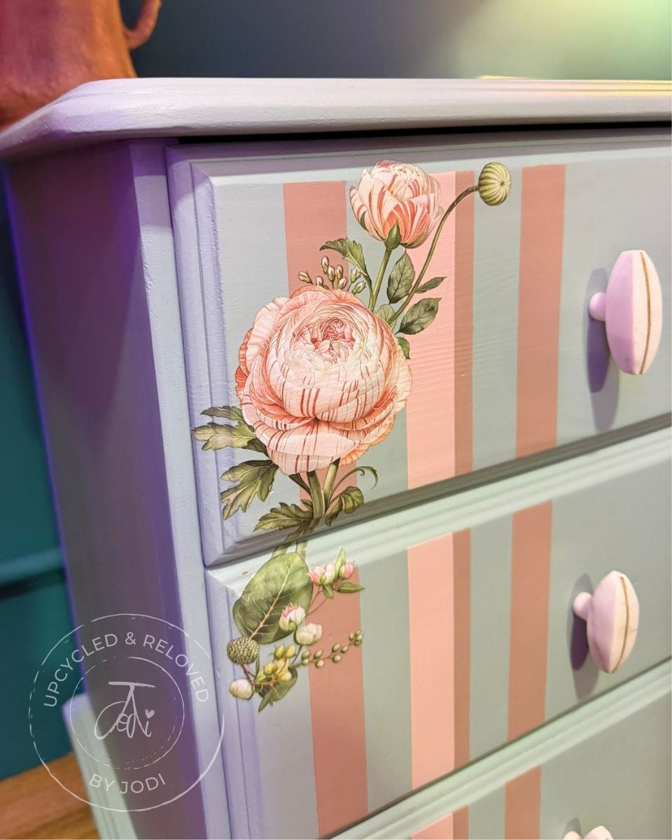 Upcycled pine bedside cabinet painted in duck egg blue, with floral design and striped pattern in pink hues. 