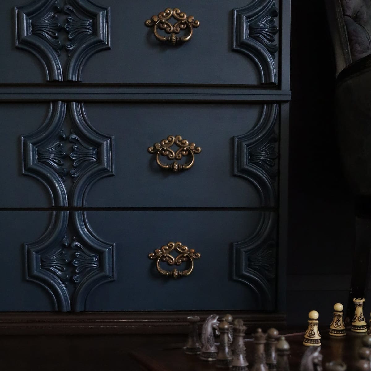 Ornate dresser painted in dark green blue Fusion Mineral Paint Chestler with gold handles and a chess board alongside