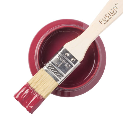 Fusion Mineral Paint in juicy deep red Cranberry on a paintbrush resting on a paint jar.
