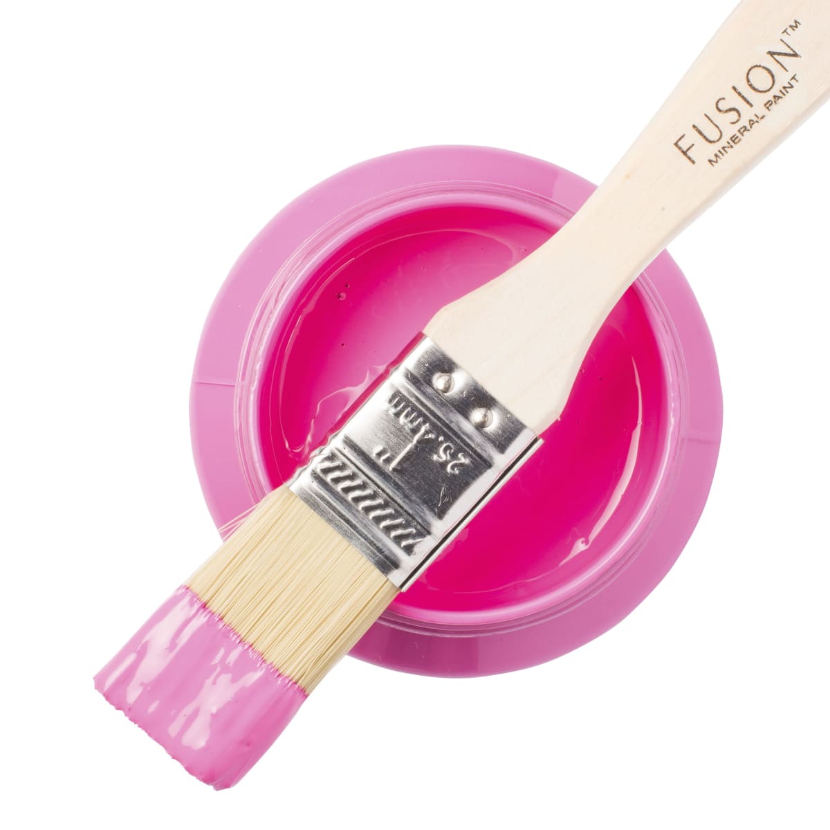 Fusion Mineral Paint in bright pink Cureiously Pink on a paintbrush resting on a paint jar.