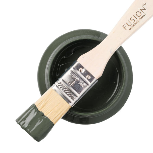 Fusion Mineral Paint in olive green Everett on a paintbrush resting on a paint jar