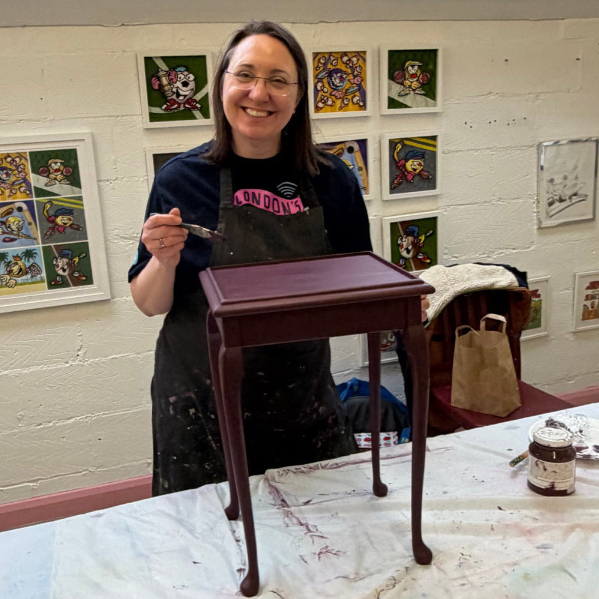 Lady smiling while painting Furniture at an Upcycling workshop in Leatherhead Surrey
