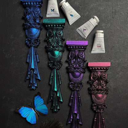 Decorative columns painted in various shimmering colours with Fusion Chromaflex Mineral Paint tubes on a dark background.