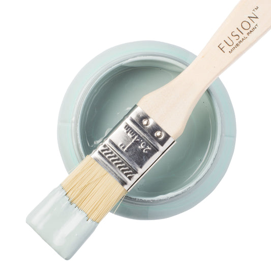 Fusion paintbrush with a container of 'Heirloom' paint on a white background.