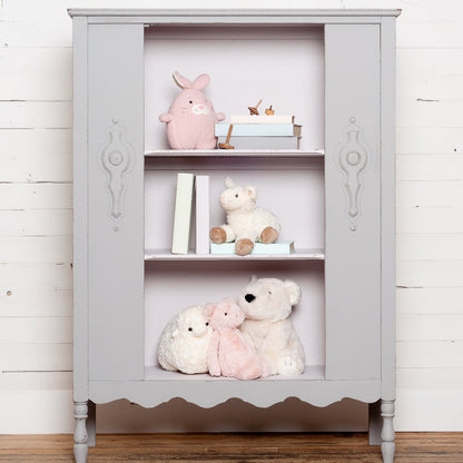 Bookshelf painted in wooly grey Little Lamb from Fusion Mineral Paint with stuffed animals against a white wooden wall,