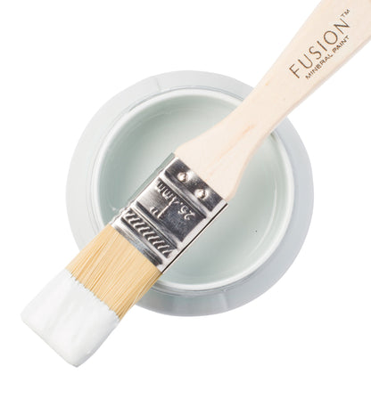 Paint brush with Little Whale paint from the Fusion Mineral Paint range sat atop a container on a white background