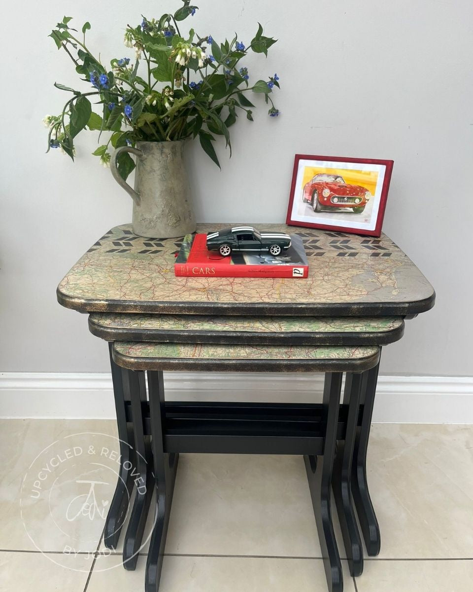 Set of three nesting tables upcycled in Fusion ash black with a map decoupage on the tops and stencilled track pattern across the top. Gold edging around the nest of tables 