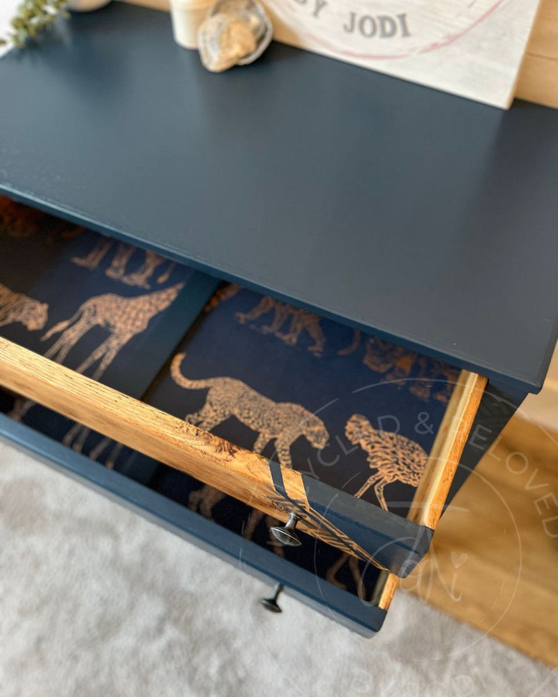 Goldy-copper animals wallpaper used as drawer lining inside an upcycled chest of drawers painted in Fusion Mineral Paint Willowbank, a rich navy blue.