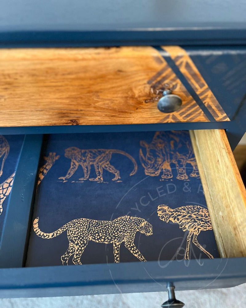 Goldy-copper animals wallpaper used as drawer lining inside an upcycled chest of drawers painted in Fusion Mineral Paint Willowbank, a rich navy blue.