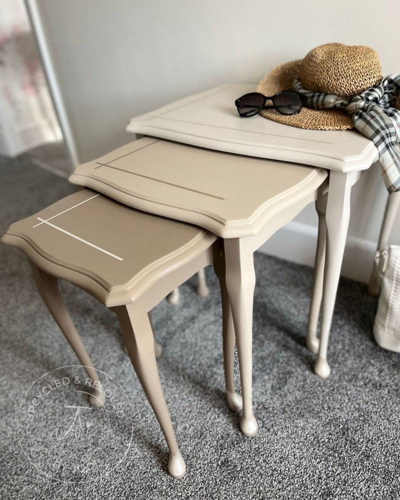 Nest of tables upcycled and painted in natural neutrals pulled out slightly and featuring 'Upcycled & Reloved by Jodi' branding