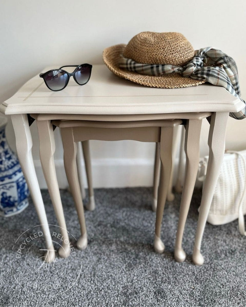 Set of three upcycled nest of tables painted in natural neutrals with decorative items on top, featuring 'Upcycled & Reloved by Jodi' branding