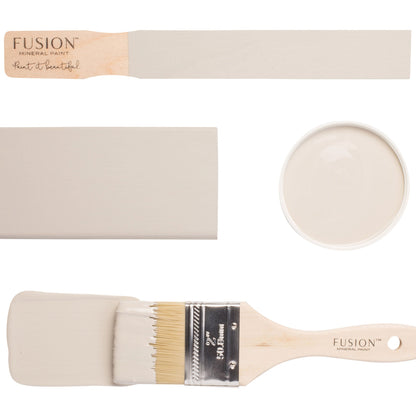 Fusion paintbrushes with Putty furniture paint sample on a brush and a sample stick. Creamy beige furniture paint sample on a white background