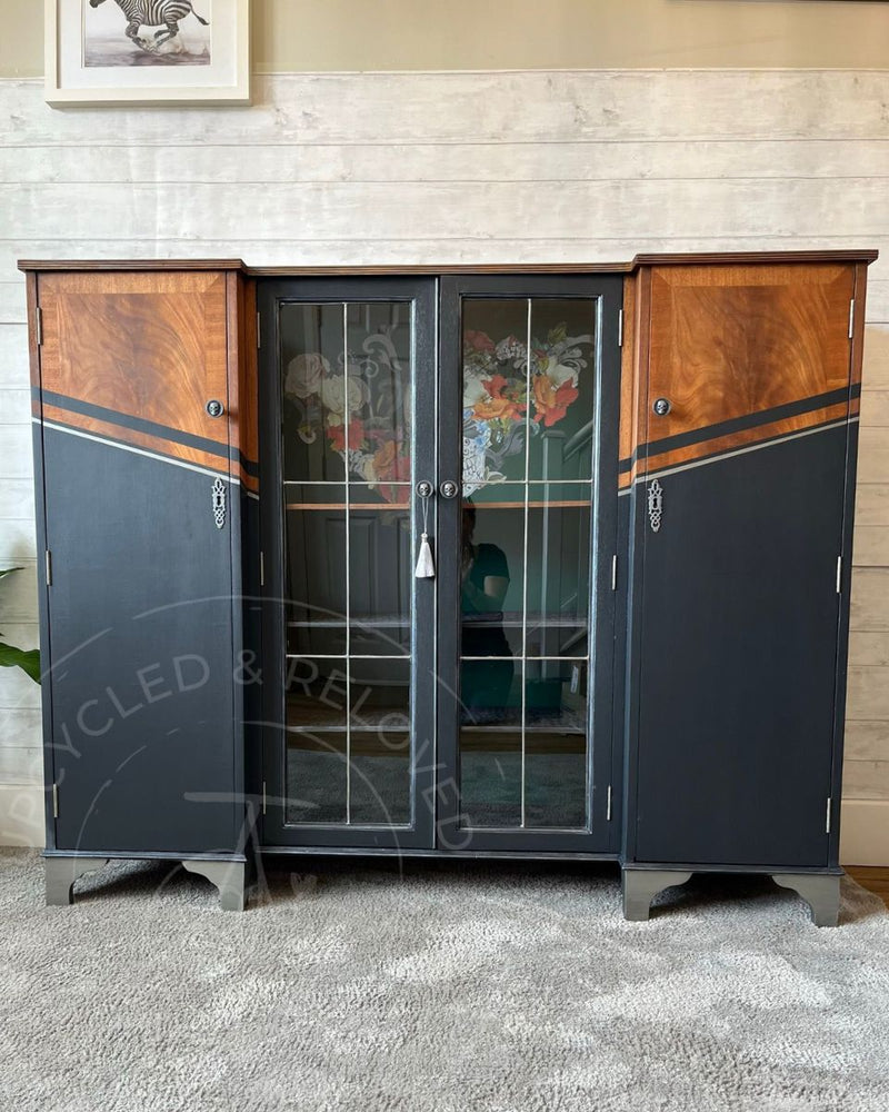 A large rum cabinet upcycled in Fusion Mineral Paint Ash with Pressed Fern green interior, exposed wood grain and silver geometric detailing by Upcycled & Reloved by Jodi.